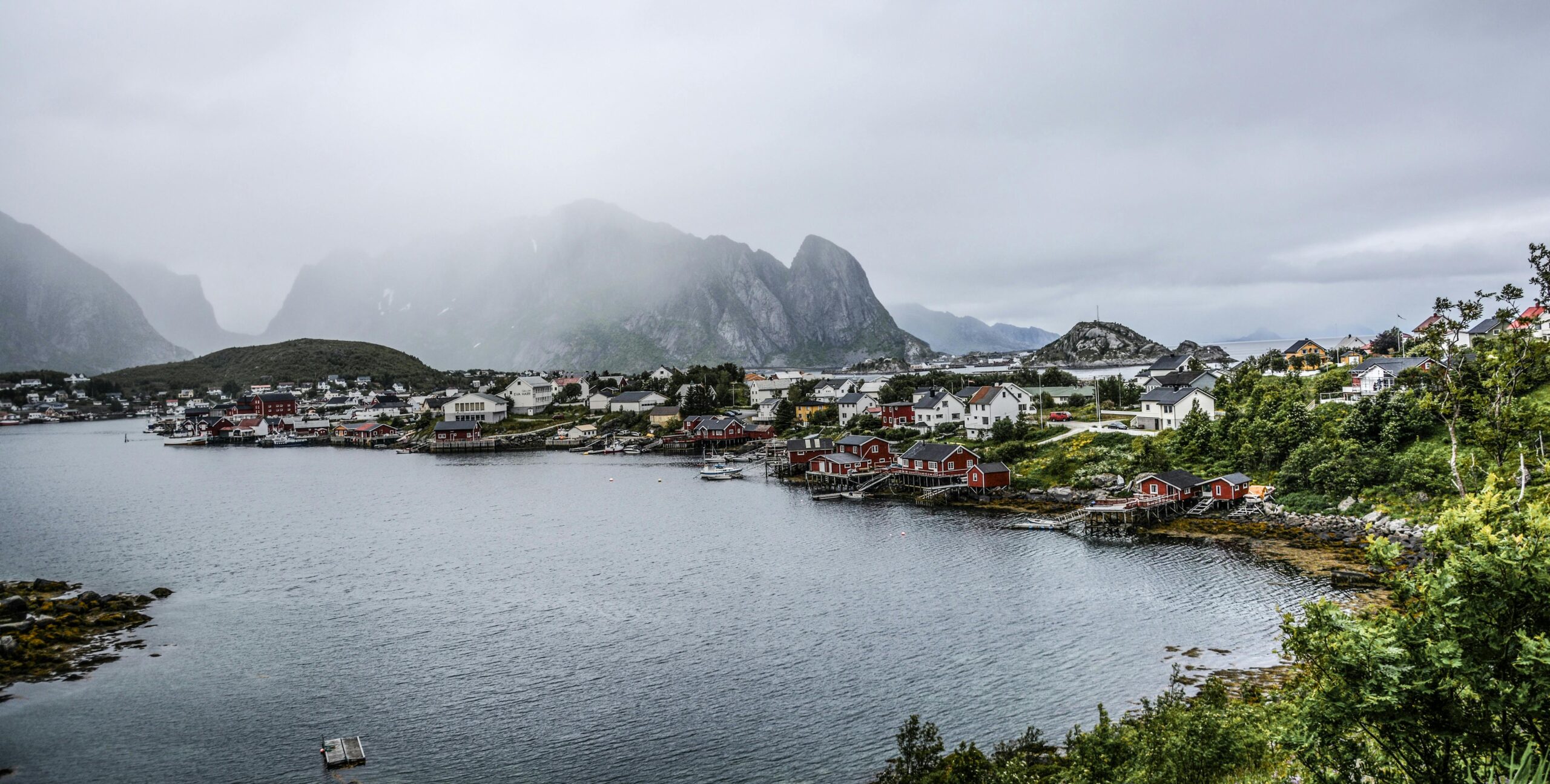 Misty harbor scene of charming village nestled along a tranquil coastline.