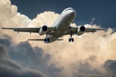 A commercial airplane flying through dramatic clouds, showcasing aviation in action.