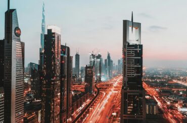 Dynamic view of Dubai's illuminated skyline featuring iconic skyscrapers at sunset.