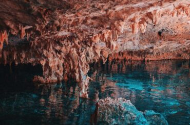 Explore the breathtaking limestone formations and clear waters in a Mexican cave.