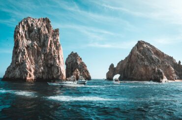 Stunning Cabo San Lucas seascape with rock formations and boats on a clear day.