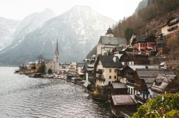 Charming winter scene of Hallstatt village, lakeside with mountains.