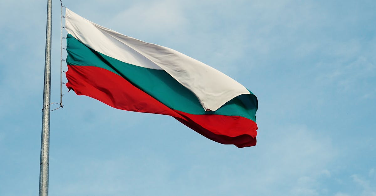 The national flag of Bulgaria waving on a flagpole against a clear blue sky in Varna.