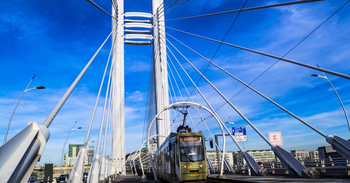 A modern urban bridge featuring an electric train in Bucharest during a clear day.