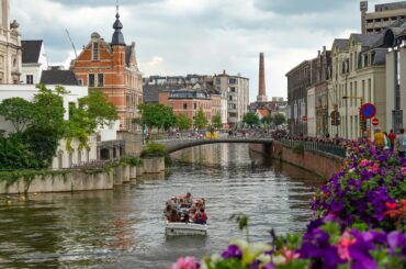 Picturesque canal scene in Ghent featuring historic buildings and a vibrant river setting.