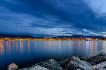 Stunning evening view of Split harbor with reflections on the Adriatic Sea, enhancing the skyline under the blue hour.