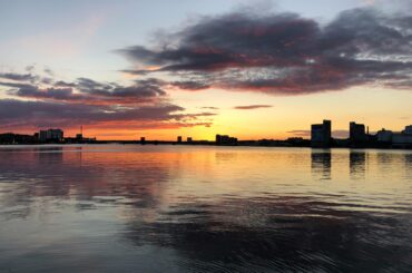 Captivating sunset with city skyline reflection on water in Aalborg, Denmark.