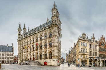 Panoramic view of the Gothic town hall in Leuven's historic Grote Markt square.