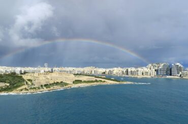 Stunning aerial view of Sliema, Malta with a rainbow over the city skyline.