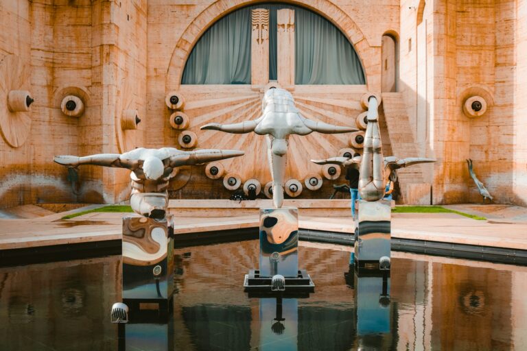 a group of sculptures sitting on top of a pool of water