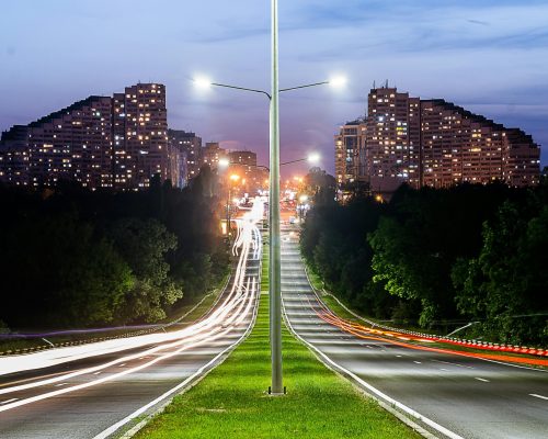 Long exposure of a highway in Chișinău showing light trails and urban skyline at night.