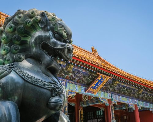 Close view of Foo Dog statue and traditional Chinese architecture at Beijing's Summer Palace.