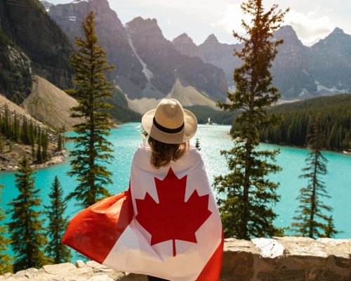 Explore the beauty of Moraine Lake in Alberta, Canada, with a stunning view and a Canadian flag.