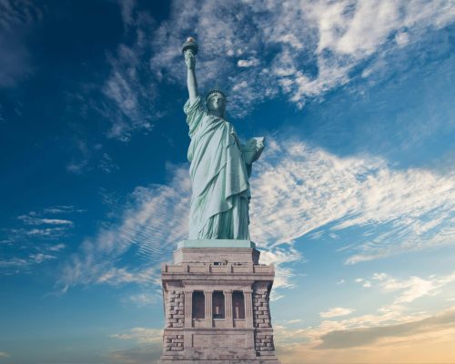Iconic Statue of Liberty with a backdrop of a vibrant blue sky, symbolizing freedom and America.