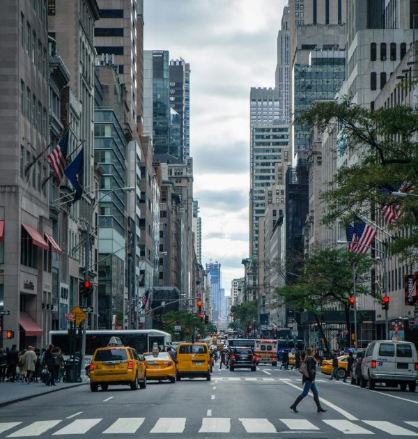 Vibrant street view of New York City with pedestrians, yellow cabs, and skyscrapers.