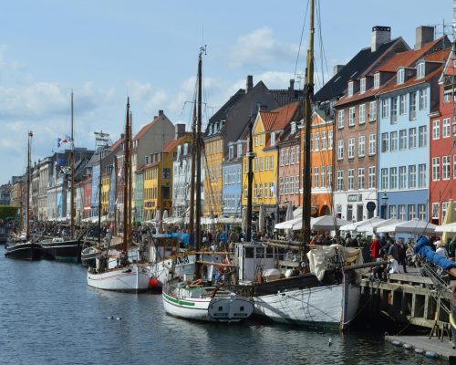 Vibrant waterfront scene of Nyhavn harbor with historic buildings and boats in Copenhagen.