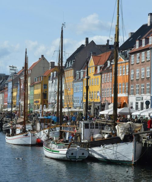 Vibrant waterfront scene of Nyhavn harbor with historic buildings and boats in Copenhagen.