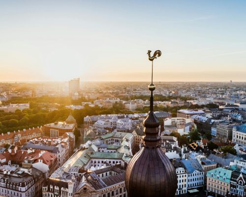 Stunning aerial view of Riga, Latvia with the sun rising over the historic cityscape and skyline.