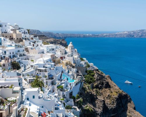 Beautiful Santorini houses overlooking the Aegean Sea on a sunny day.